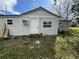 Exterior view of the home, showcasing the white siding, small windows, door and air conditioner at 309 Old Mission Rd, New Smyrna Beach, FL 32168
