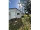 Exterior view of the home highlighting the small window, door and air conditioner at 309 Old Mission Rd, New Smyrna Beach, FL 32168