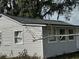 Exterior view of the home featuring the side with small windows and the gray roof at 309 Old Mission Rd, New Smyrna Beach, FL 32168