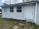 Exterior view of a small house with white siding and a white door at 309 Old Mission Rd, New Smyrna Beach, FL 32168