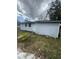 An exterior view of the home showcasing the side with windows and the white door at 309 Old Mission Rd, New Smyrna Beach, FL 32168