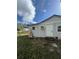 Exterior view of the home featuring white siding, small windows and an air conditioner at 309 Old Mission Rd, New Smyrna Beach, FL 32168