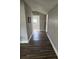 Hallway features dark wood-look floors and neutral gray walls, leading to another room at 309 Old Mission Rd, New Smyrna Beach, FL 32168