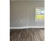 This room has wood-look flooring, an electrical outlet, and a window view of the outdoors at 309 Old Mission Rd, New Smyrna Beach, FL 32168