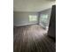 Room featuring two windows, gray walls, wood-look flooring, and an open door at 309 Old Mission Rd, New Smyrna Beach, FL 32168