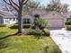 Charming single-Gathering home featuring a manicured lawn, mature trees, and a two-car garage at 3623 Eversholt St, Clermont, FL 34711