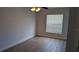 Simple bedroom with neutral walls, light wood floors, a ceiling fan, and a bright window at 3654 Peppervine Dr, Orlando, FL 32828