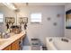 Relaxing bathroom with dual sinks, soaking tub, and modern fixtures at 402 Bramble Way, Minneola, FL 34715