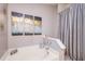 Bathroom featuring a luxurious soaking tub, elegant artwork, and modern finishes at 402 Bramble Way, Minneola, FL 34715