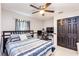 Bedroom with a ceiling fan, gray walls, striped comforter, and dark wood furniture at 402 Bramble Way, Minneola, FL 34715