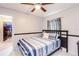 Bedroom with a striped comforter, ceiling fan, and dark wood door at 402 Bramble Way, Minneola, FL 34715