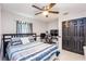 Bedroom with a ceiling fan, gray walls, striped comforter, and dark wood furniture at 402 Bramble Way, Minneola, FL 34715