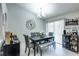 Elegant dining room with modern chandelier, gray upholstered chairs, and a sliding glass door for natural light at 402 Bramble Way, Minneola, FL 34715