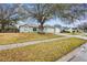 Single Gathering home with a light green exterior and mature trees at 402 Bramble Way, Minneola, FL 34715