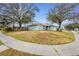 Single Gathering home with a light green exterior and mature trees at 402 Bramble Way, Minneola, FL 34715