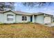 Inviting front exterior featuring a well-maintained lawn, blue front door and attached two car garage at 402 Bramble Way, Minneola, FL 34715