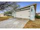 Attached two-car garage with a light green exterior at 402 Bramble Way, Minneola, FL 34715