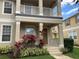 Inviting two-story home featuring a cozy front porch and balcony with decorative landscaping at 7117 Red Lantern Dr # 7117, Harmony, FL 34773