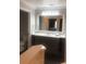 Bathroom featuring a dark vanity, large mirror reflecting the shower and toilet at 7697 Heritage Crossing Way # 302, Reunion, FL 34747