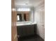 Bathroom featuring a dark vanity, large mirror, and great lighting at 7697 Heritage Crossing Way # 302, Reunion, FL 34747
