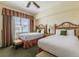 Comfortable bedroom with two twin beds and ample natural light at 7697 Heritage Crossing Way # 302, Reunion, FL 34747