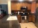 Modern kitchen features stainless steel appliances, tile floors, and a breakfast bar at 7697 Heritage Crossing Way # 302, Reunion, FL 34747