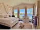 Cozy bedroom featuring views of lake, adorned with floral accents and soft pink hues at 800 Stephens Pass Cv, Lake Mary, FL 32746