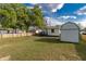 Expansive backyard featuring lush green grass, rear deck, and additional storage shed at 906 Se 3Rd St, Mulberry, FL 33860