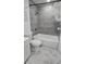 Bathroom features a tiled shower/tub combination with a gray-tile surround, toilet, and marble-look floors at 906 Se 3Rd St, Mulberry, FL 33860