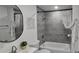 Stylish bathroom showcasing a bathtub with gray tile surround, a modern sink, and a decorative mirror at 906 Se 3Rd St, Mulberry, FL 33860