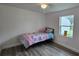 Cozy bedroom featuring modern flooring, a window, and a comfortable bed with butterfly-themed bedding at 906 Se 3Rd St, Mulberry, FL 33860