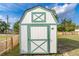 Backyard shed with a white and green exterior providing extra storage space at 906 Se 3Rd St, Mulberry, FL 33860