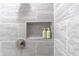 Close-up of a modern shower with sleek gray tile and built-in niche for toiletries at 906 Se 3Rd St, Mulberry, FL 33860