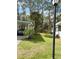 Well-manicured lawn and a mature palm tree by the carport at 103 Bougainvillea Dr, Leesburg, FL 34748