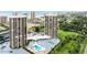 Scenic aerial view of two high-rise condos with pools and landscaping, highlighting amenities at 1 Oceans West Blvd # 3B4, Daytona Beach, FL 32118
