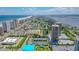 Expansive aerial view showcasing the coastal community, tennis courts, ocean, and city skyline at 1 Oceans West Blvd # 3B4, Daytona Beach, FL 32118