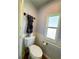 Cozy bathroom with toilet, sink, and window with natural light at 114 Caladium St, Leesburg, FL 34748