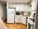 Functional kitchen featuring white cabinetry, laminate countertops, and modern appliances at 114 Caladium St, Leesburg, FL 34748