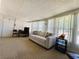 Comfortable living room featuring a plush sofa, work space, and an abundance of natural light at 114 Caladium St, Leesburg, FL 34748