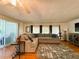 Inviting living room with large sectional sofa, stylish area rug, and plenty of natural light at 114 Caladium St, Leesburg, FL 34748