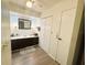 Bathroom with a vanity, a large mirror, and ample cabinet storage at 123 Pyracantha Ln, Leesburg, FL 34748