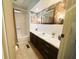 Bathroom with tub/shower combo, decorative wallpaper, and tiled floors at 123 Pyracantha Ln, Leesburg, FL 34748