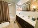 Bathroom with a bathtub, vanity with storage, and modern floral wallpaper at 123 Pyracantha Ln, Leesburg, FL 34748