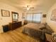 Bedroom with wood floors, ceiling fan, and window with patterned curtains at 123 Pyracantha Ln, Leesburg, FL 34748