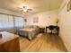 Bedroom features wood floors, a ceiling fan, a dresser, a desk with chair, and natural light at 123 Pyracantha Ln, Leesburg, FL 34748