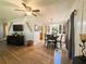 Open concept dining room with modern light fixture, wood floors, and a large display cabinet at 123 Pyracantha Ln, Leesburg, FL 34748