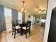 Bright dining area with a wood table, modern light fixture, wood floors, and neutral walls at 123 Pyracantha Ln, Leesburg, FL 34748