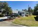 Cozy home with manicured lawn and garden, covered entrance, and ample parking on a sunny day at 123 Pyracantha Ln, Leesburg, FL 34748