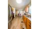 Galley kitchen with stainless steel appliances, oak cabinets, and modern lighting at 123 Pyracantha Ln, Leesburg, FL 34748