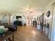Spacious living room with a dining table, wood floors, a large entertainment center, and neutral decor at 123 Pyracantha Ln, Leesburg, FL 34748
